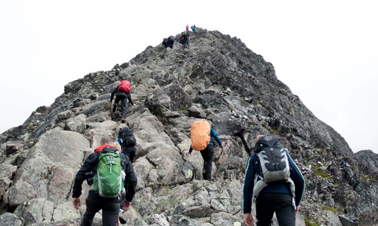 Hikers near a rocky mountain peak.