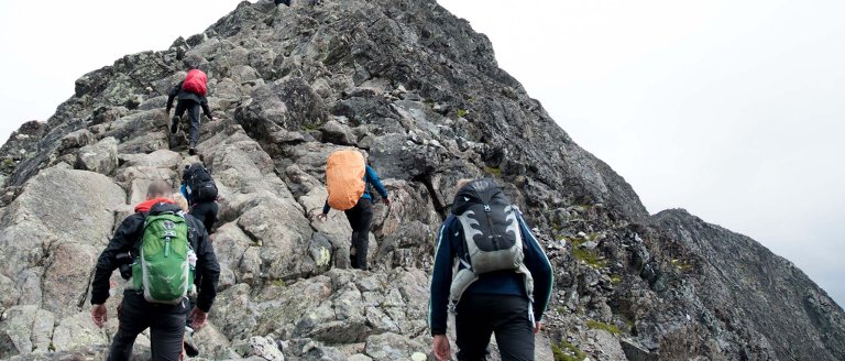 Hikers near a rocky mountain peak.